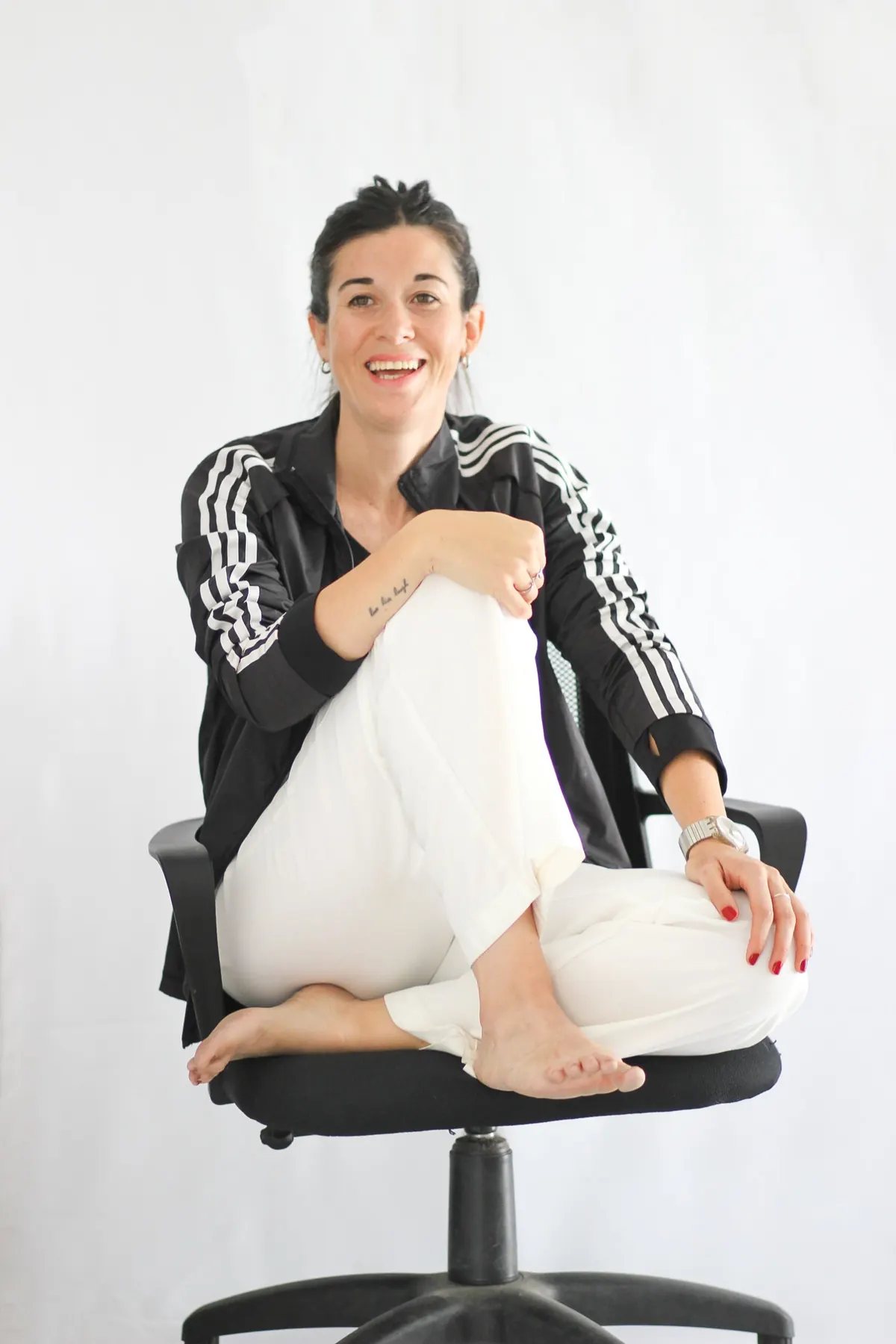 María Pía Ané Gaitón riendo, sentada en una silla de oficina